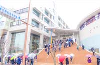 福岡県立博多青松高校の前期２期入試当日の様子、雨の中入り口に向かう受検生たち。